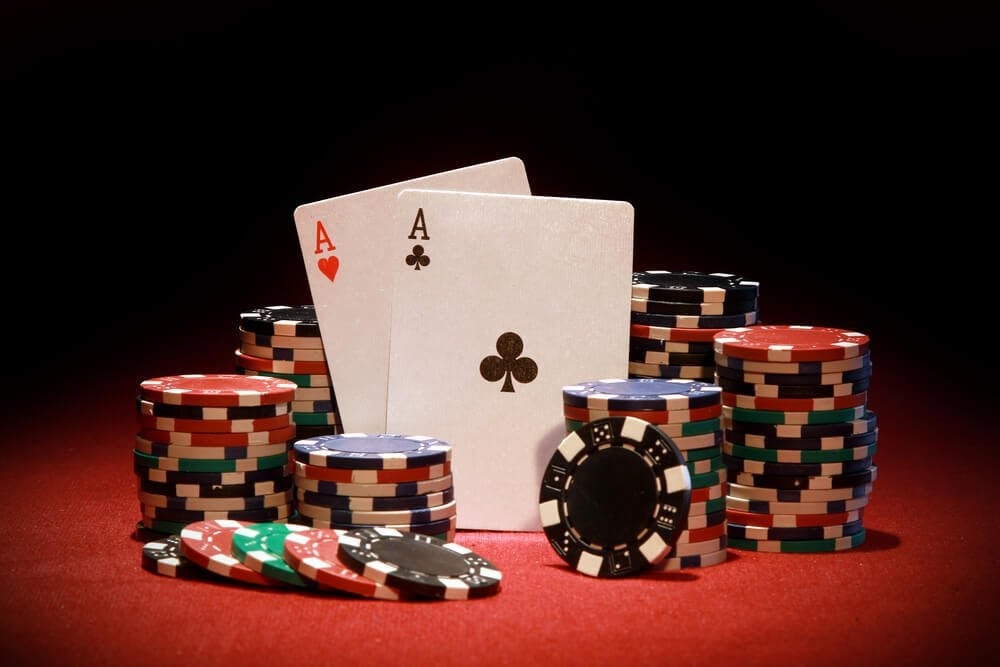 Pokerchips mit Ass-Paar auf Pokertisch